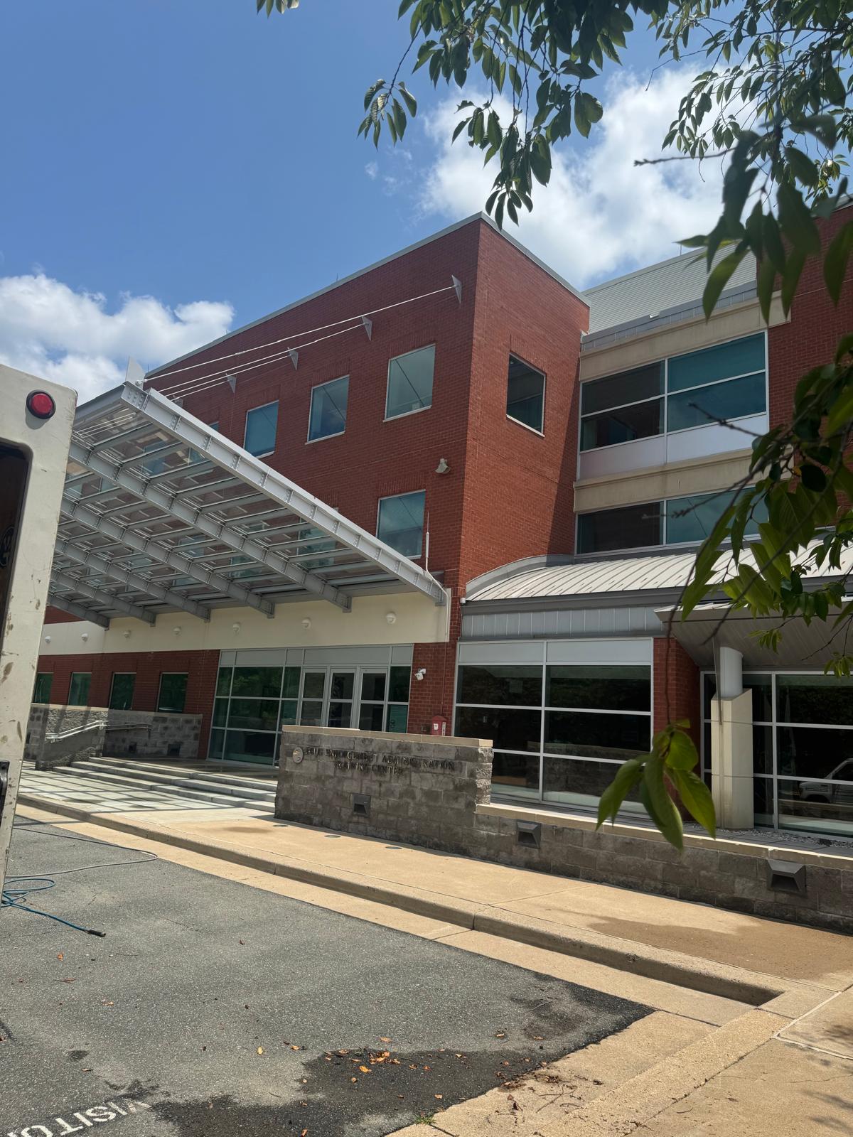 Clean red brick commercial building exterior with glass entrance