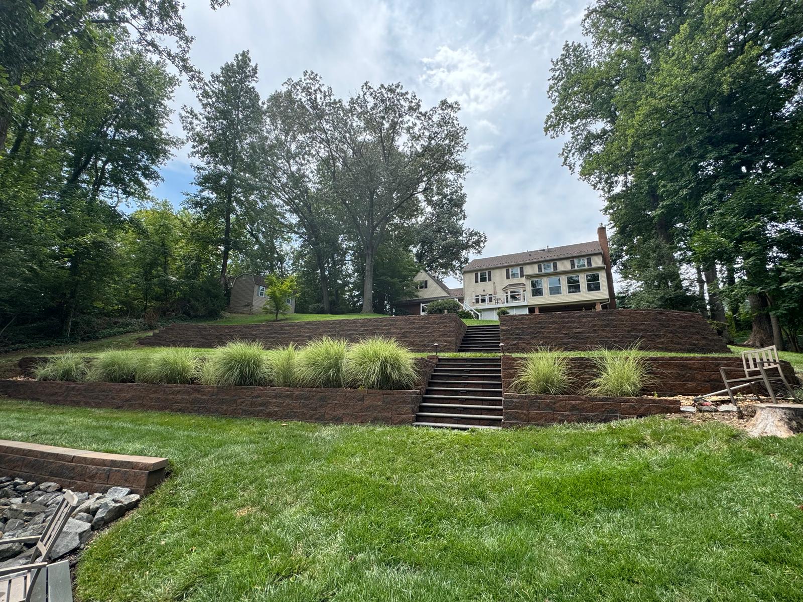 Cleaned stone retaining wall and steps in a backyard